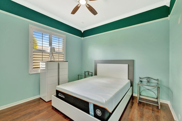 bedroom featuring baseboards, a ceiling fan, crown molding, and wood finished floors
