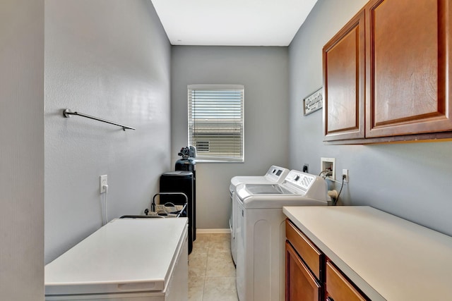 laundry room with cabinet space, baseboards, light tile patterned floors, and washing machine and clothes dryer