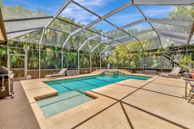 view of pool featuring area for grilling, a patio, a pool with connected hot tub, and glass enclosure