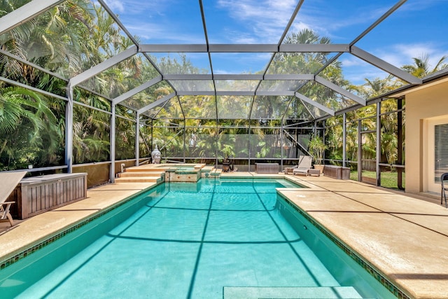 view of swimming pool featuring a patio, a pool with connected hot tub, and a lanai