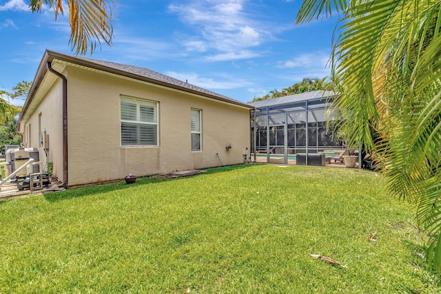 back of house with a lawn, a swimming pool, and stucco siding