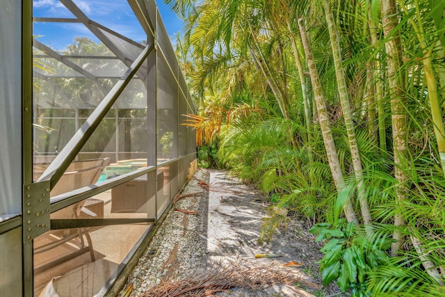 view of home's exterior with glass enclosure, a patio area, and an outdoor pool