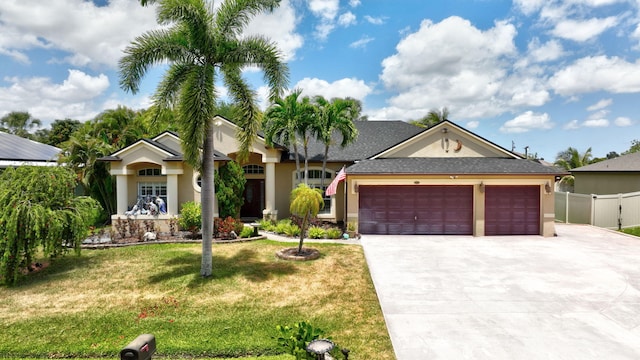 view of front of property featuring a garage, stucco siding, driveway, and a front lawn
