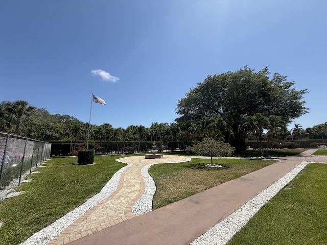 view of property's community featuring a yard and fence