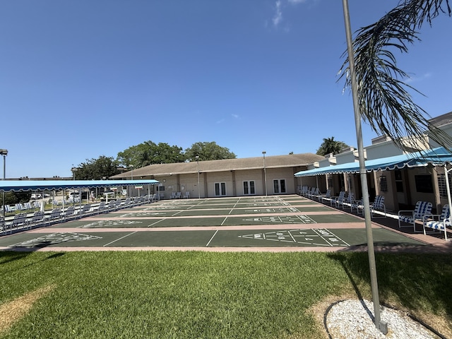 surrounding community featuring a lawn and shuffleboard