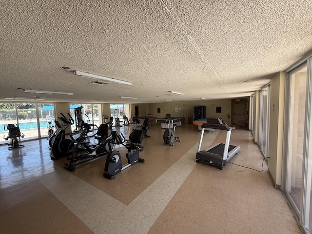 workout area with a textured ceiling, a wealth of natural light, and light floors