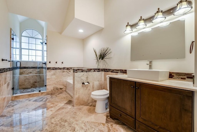 16239 121st Ter N, Jupiter, FL 33478 - full bath with tile walls, a stall shower, vanity, a wainscoted wall, and toilet