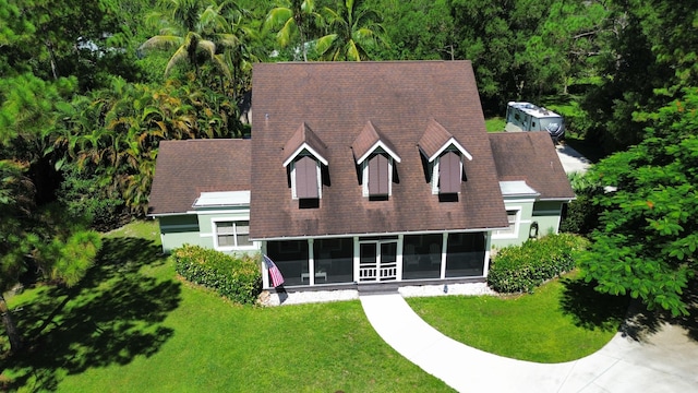 16239 121st Ter N, Jupiter, FL 33478 - view of front of house featuring a view of trees, a sunroom, and a front lawn