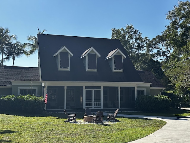 16239 121st Ter N, Jupiter, FL 33478 - cape cod-style house with a front lawn, a sunroom, and an outdoor fire pit