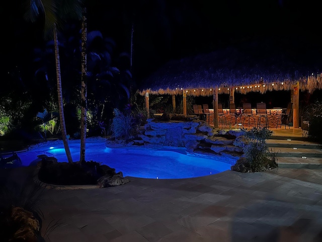 16239 121st Ter N, Jupiter, FL 33478 - pool at night featuring a gazebo, outdoor dry bar, a patio area, and an outdoor pool