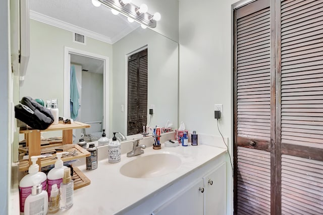 bathroom with visible vents, ornamental molding, a closet, and vanity