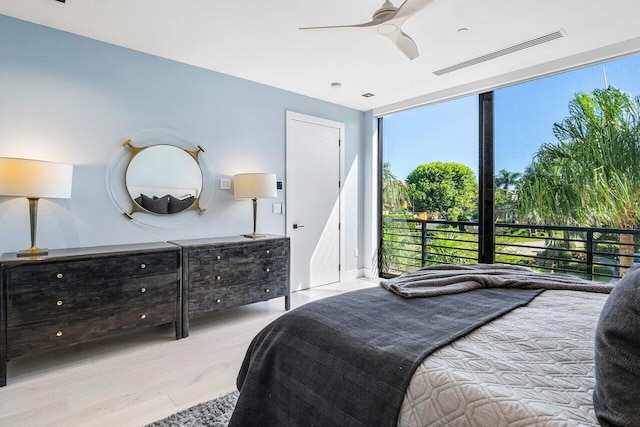 914 Palm Trl, Delray Beach, FL 33483 - bedroom with ceiling fan, visible vents, a wall of windows, and wood finished floors