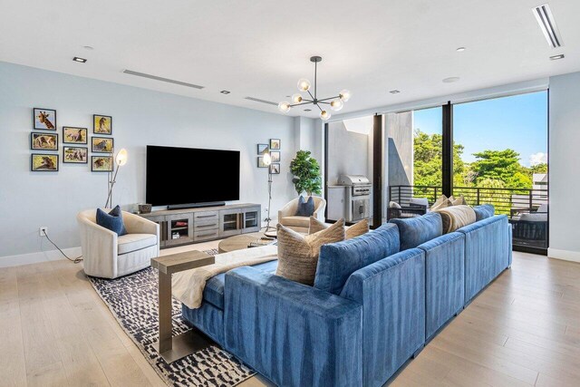 914 Palm Trl, Delray Beach, FL 33483 - living area featuring an inviting chandelier, baseboards, visible vents, and light wood-type flooring