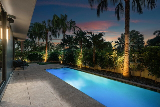 914 Palm Trl, Delray Beach, FL 33483 - pool at dusk with a fenced backyard, a patio, and an outdoor pool
