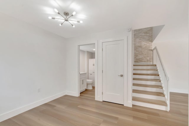 2003 20th Way, West Palm Beach, FL 33407 - stairway featuring a chandelier, wood finished floors, and baseboards