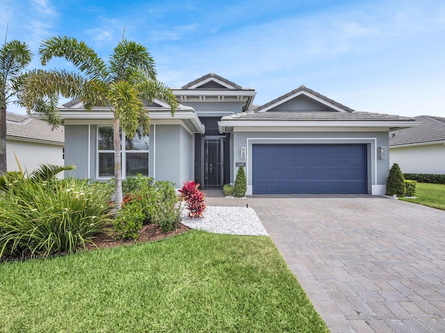 12495 SW Sunrise Lake Ter, Port Saint Lucie, FL 34987 - view of front facade featuring decorative driveway, a garage, stucco siding, and a front lawn