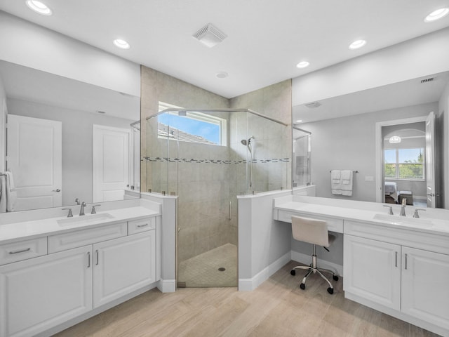 12495 SW Sunrise Lake Ter, Port Saint Lucie, FL 34987 - bathroom featuring connected bathroom, a stall shower, wood finished floors, two vanities, and recessed lighting