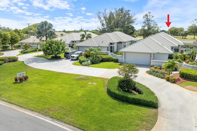 single story home with an attached garage, curved driveway, and a front yard