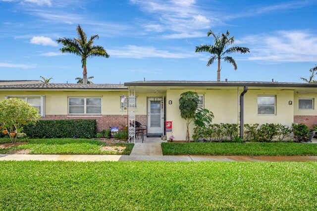 2811 Ashley Dr E Unit E, West Palm Beach, FL 33415 - ranch-style home featuring brick siding, a front lawn, and stucco siding