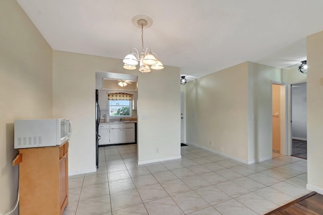 2811 Ashley Dr E Unit E, West Palm Beach, FL 33415 - unfurnished dining area featuring baseboards, light tile patterned flooring, and a chandelier