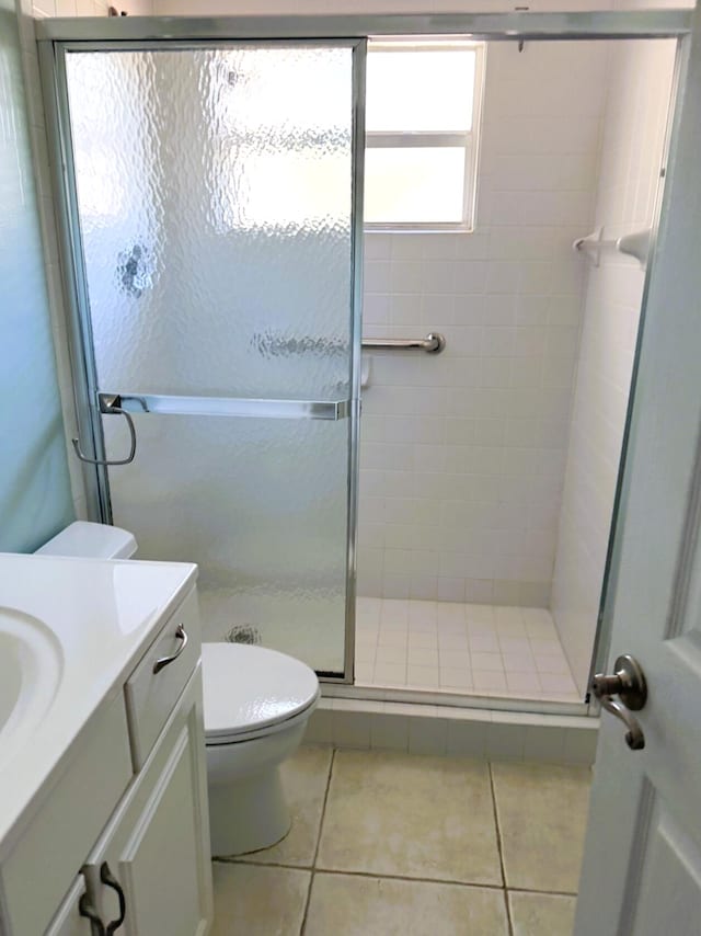 full bath with vanity, toilet, tile patterned floors, and a stall shower