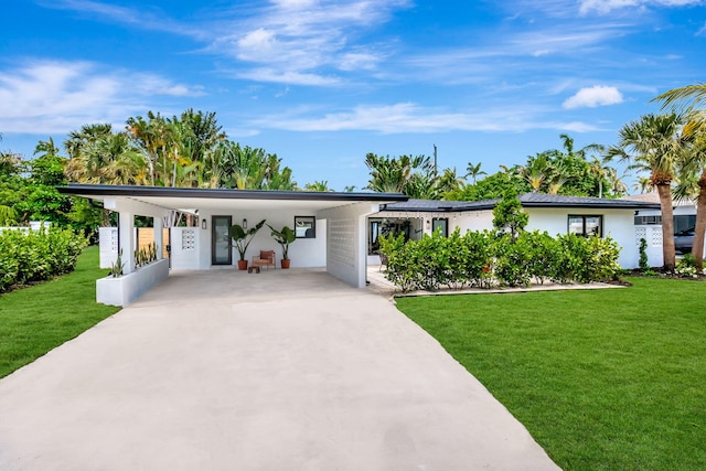 view of front facade with driveway, a front yard, and a carport