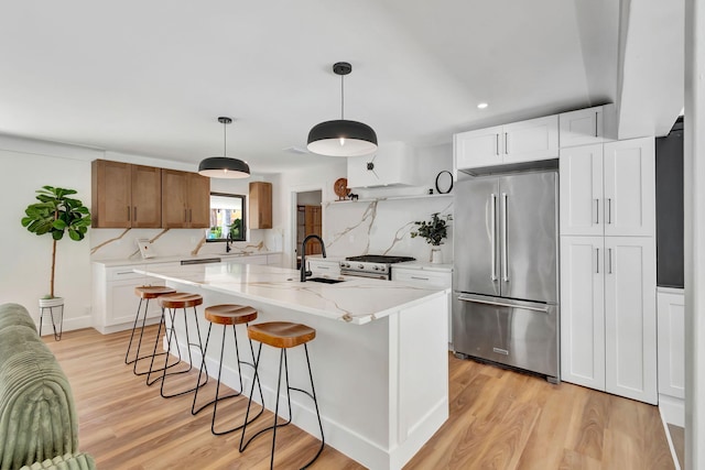 kitchen with a sink, stainless steel appliances, and light wood-style flooring