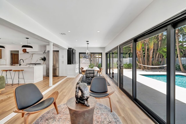 living area with recessed lighting, visible vents, and light wood-style flooring