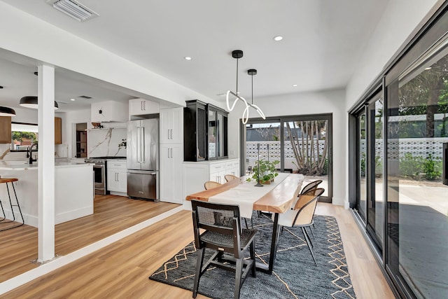 dining room featuring recessed lighting, visible vents, a healthy amount of sunlight, and light wood-type flooring
