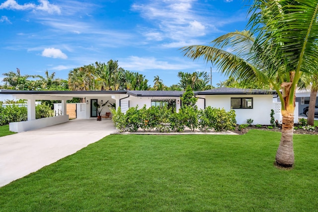 view of front of property featuring a carport, a front lawn, driveway, and stucco siding