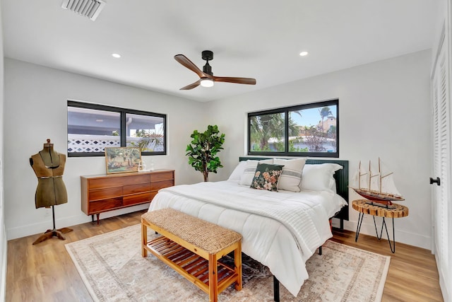 bedroom featuring visible vents, light wood-style flooring, and baseboards
