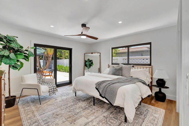 bedroom featuring access to outside, recessed lighting, multiple windows, and light wood-type flooring