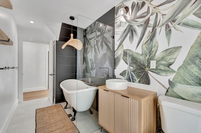 bathroom with vanity, a freestanding tub, walk in shower, and toilet