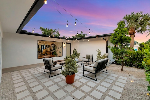 patio terrace at dusk featuring an outdoor living space