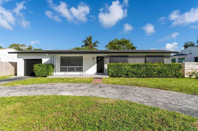 2607 Wiley St, Hollywood, FL 33020 - view of front of property with fence, a front lawn, a garage, stucco siding, and driveway