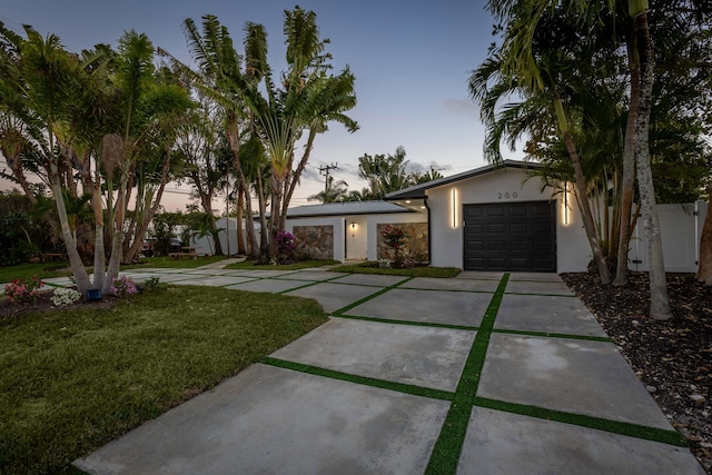 200 SW 12th St, Boca Raton, FL 33432 - mid-century modern home featuring an attached garage, a lawn, stucco siding, and concrete driveway