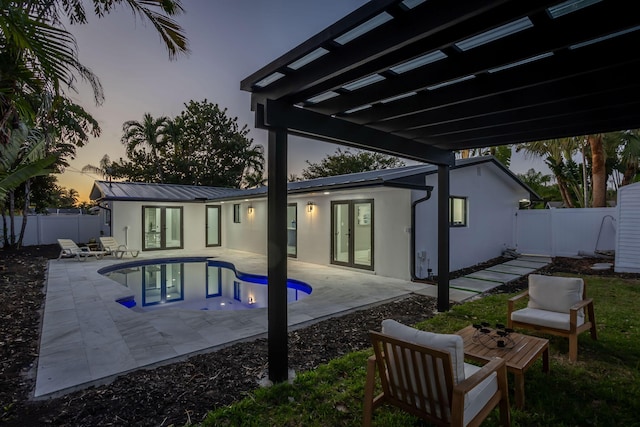 200 SW 12th St, Boca Raton, FL 33432 - back of house at dusk with stucco siding, a fenced in pool, a fenced backyard, a patio area, and french doors