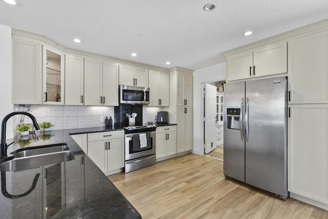 1693 Woodbridge Lakes Cir, West Palm Beach, FL 33406 - kitchen featuring appliances with stainless steel finishes, a sink, light wood-style floors, tasteful backsplash, and recessed lighting