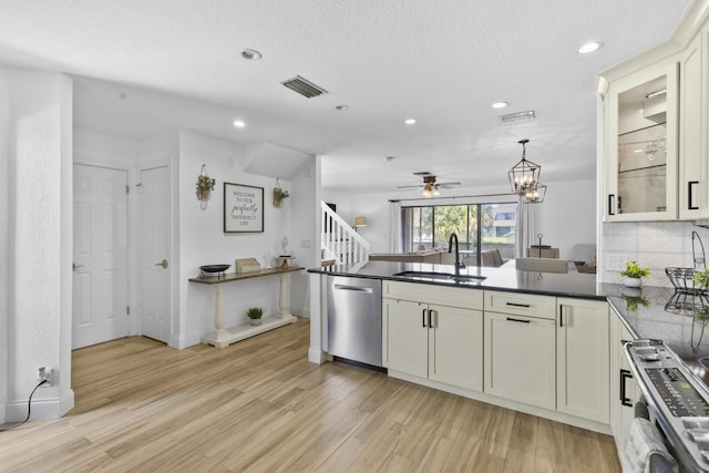 1693 Woodbridge Lakes Cir, West Palm Beach, FL 33406 - kitchen with a sink, appliances with stainless steel finishes, a peninsula, light wood-style flooring, and dark countertops