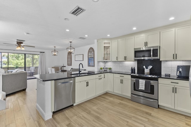 1693 Woodbridge Lakes Cir, West Palm Beach, FL 33406 - kitchen featuring appliances with stainless steel finishes, a sink, open floor plan, a peninsula, and decorative backsplash
