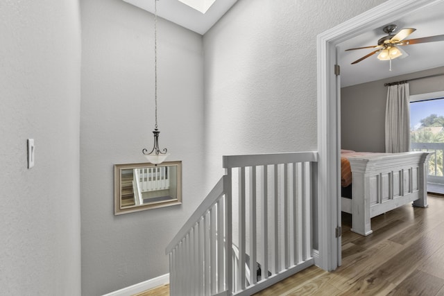 1693 Woodbridge Lakes Cir, West Palm Beach, FL 33406 - hallway with wood finished floors, a skylight, baseboards, and a textured wall
