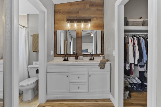 1693 Woodbridge Lakes Cir, West Palm Beach, FL 33406 - full bath featuring a ceiling fan, double vanity, wood finished floors, and toilet