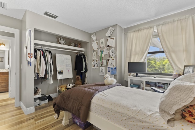 1693 Woodbridge Lakes Cir, West Palm Beach, FL 33406 - bedroom with wood finished floors, a closet, a textured ceiling, and baseboards