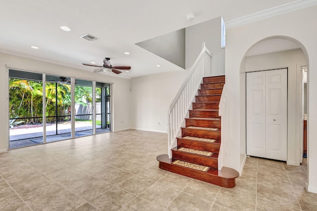 stairs featuring a ceiling fan, arched walkways, visible vents, and recessed lighting
