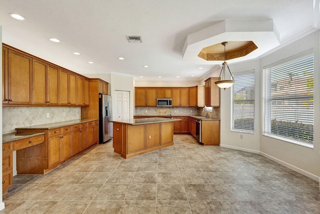 kitchen with brown cabinets, a center island, stainless steel appliances, recessed lighting, and decorative backsplash