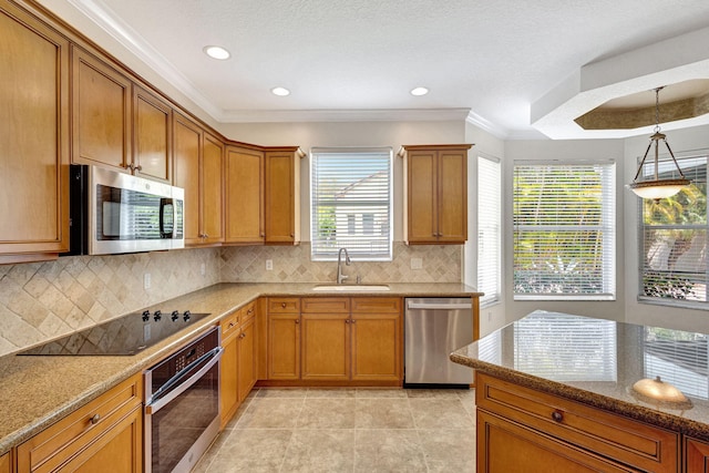 kitchen with ornamental molding, light stone countertops, brown cabinets, a sink, and stainless steel appliances