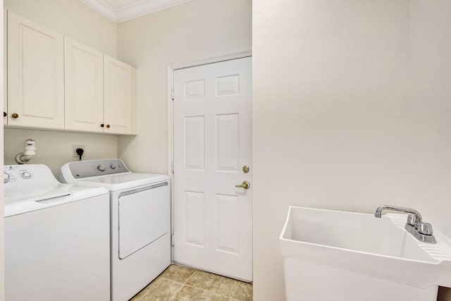 clothes washing area featuring a sink, crown molding, cabinet space, and washer and dryer