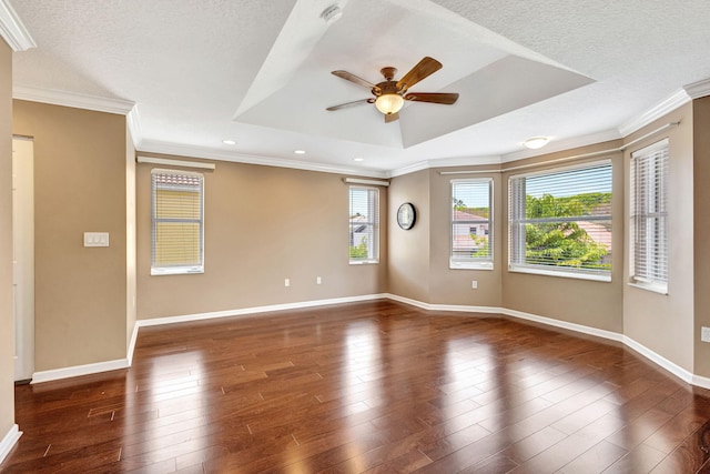 empty room with baseboards, ornamental molding, a ceiling fan, and a raised ceiling