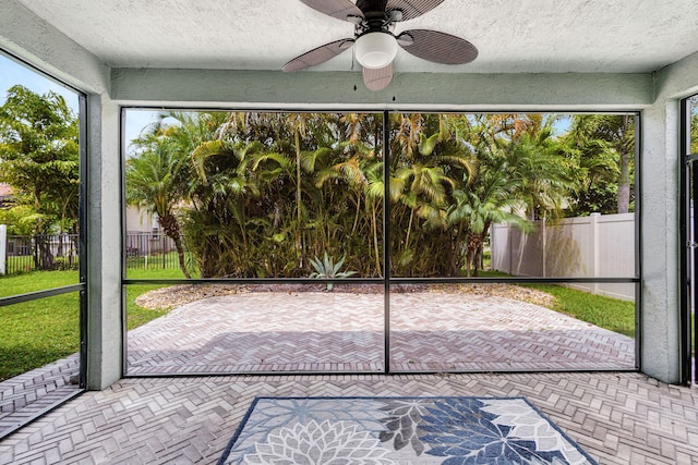 unfurnished sunroom featuring ceiling fan