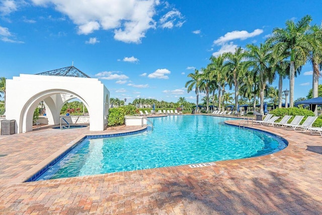 community pool featuring a patio area and central air condition unit